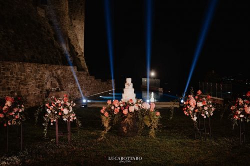 Cake cutting ceremony at Castello di Rocca Cilento with panoramic night view.